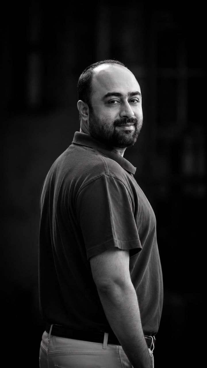 Prof. Dr. Faisal Amin Baig, photographed in black and white against a dark background.